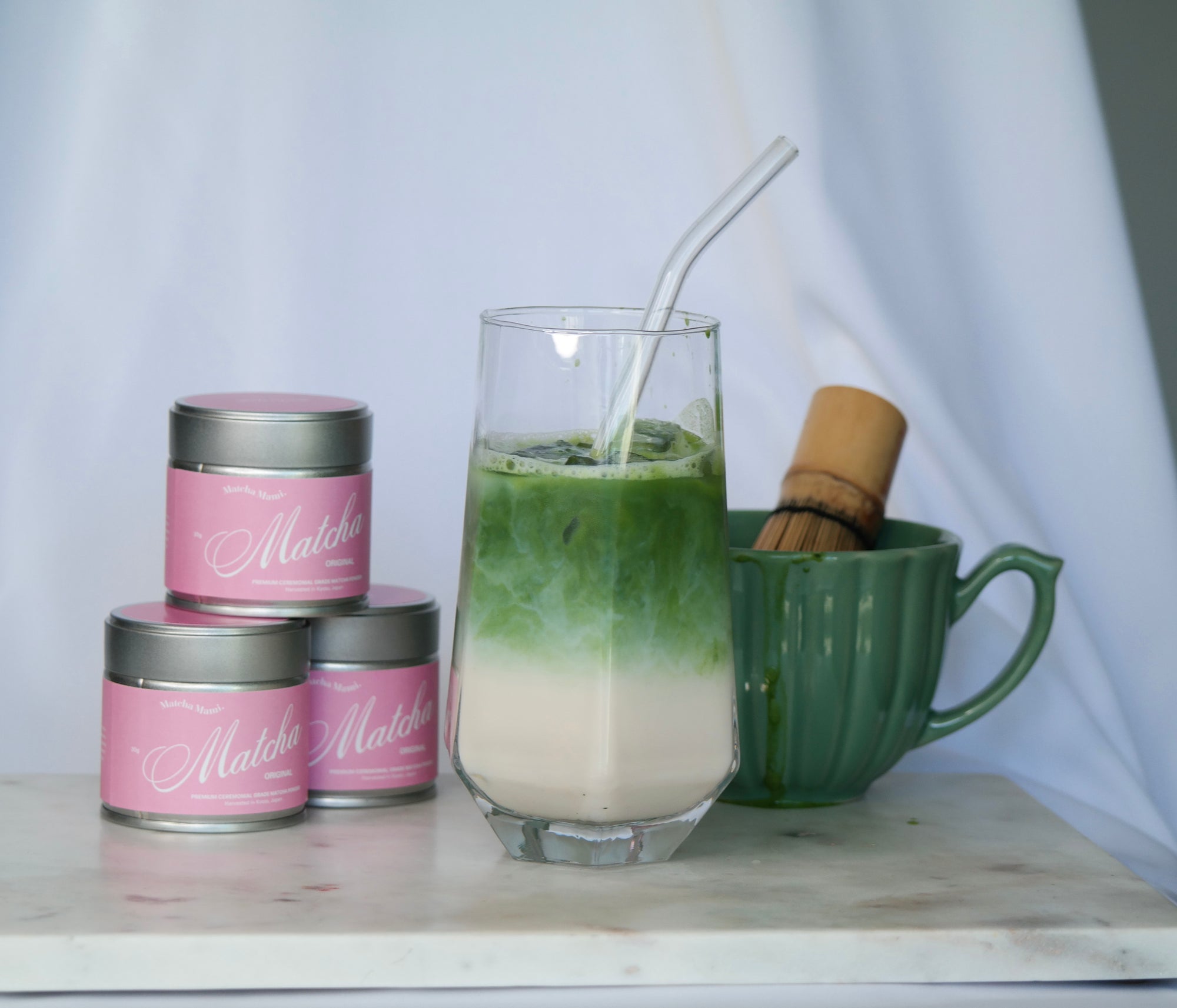 matcha green tea product shot with matcha drink and bamboo whisk in a bowl