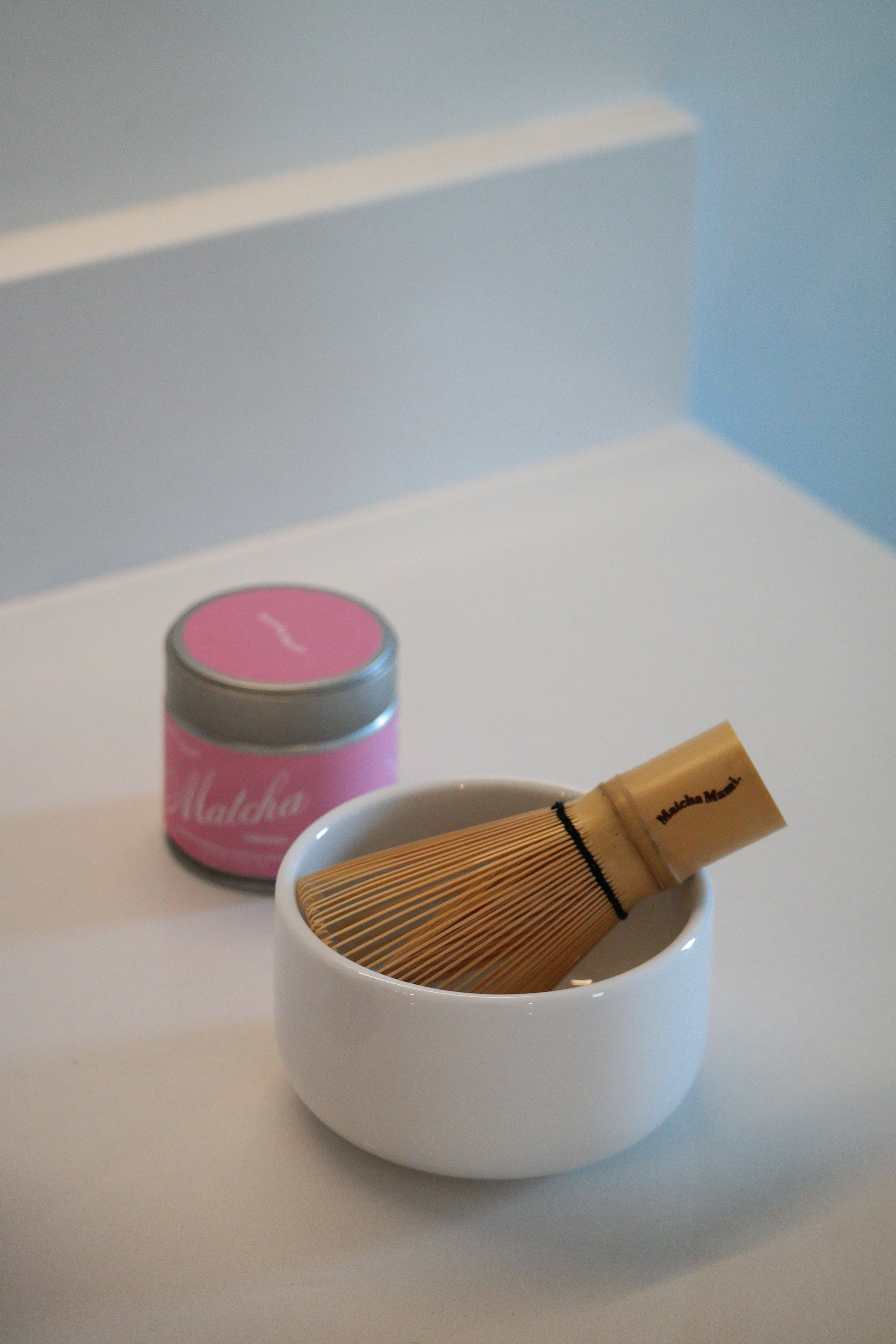 bamboo whisk chasen in a bowl with matcha green team in background